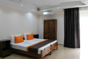 1 dormitorio con 1 cama grande con almohadas de color naranja en Saba en Shekhvetili