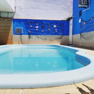 a swimming pool with blue water in a building at AP mobiliado em Guaibim in Guaibim