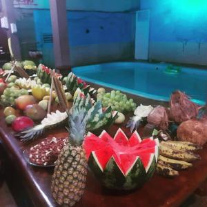 a table topped with fruits and vegetables next to a swimming pool at AP mobiliado em Guaibim in Guaibim