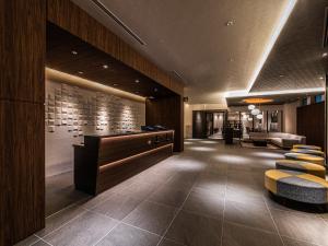 松山Hotel Vista Matsuyama的酒店大堂，配有椅子和接待台。