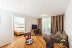 a living room with a table and a couch at Naturoase Appartements Mirnock in Afritz +145 photos