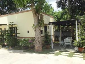 a house with a tree in the yard at Felicitas Tagaytay in Tagaytay