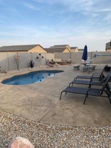 a patio with two chairs and a swimming pool at New Bullheadcity Pool Home Great Rates 5 Star in Bullhead City