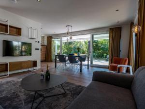 a living room with a couch and a table at Energy neutral villa with wellness area in Den Burg