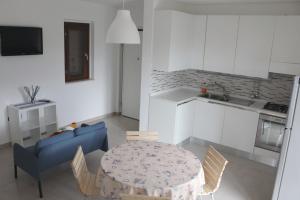 sala de estar con mesa y sofá azul en Appartamento “il borgo”, tranquillità e cura a 2 km dal mare en San Vito Chietino