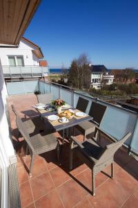 a dining table and chairs on a balcony at Ostseeresidenz Schönberger Strand in Schönberger Strand