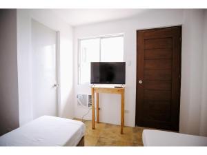 Habitación con puerta, TV y ventana en OYO 789 Abn Residences en Bacólod