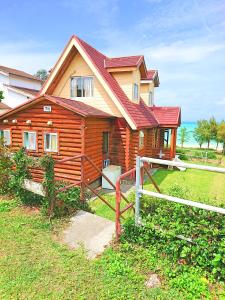 una casa de madera con una valla delante en Garden Beach House, en Motobu