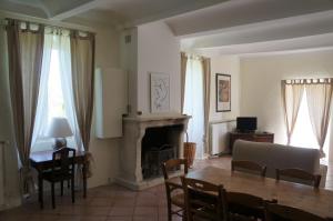 a living room with a table and a fireplace at Le Mas de Baraud in Villeneuve-de-Berg