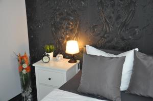 ザスニッツにあるPension & Ferienwohnungen Schneidereitのベッドルーム1室(ナイトスタンドにランプ付)