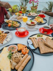 a table with many plates of food on it at Huvan Beach Hotel at Hulhumale in Hulhumale