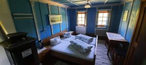 a blue room with a bed and a table at Unser kleines Bauernhaus in Maria Luggau
