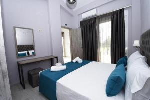 a bedroom with a large bed with a blue blanket at GERANI apartments in Órmos