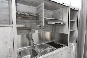 a kitchen with a stainless steel sink and a counter at GERANI apartments in Órmos