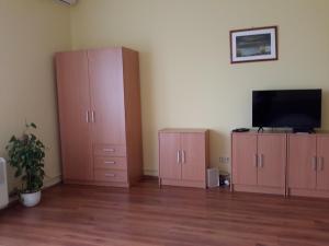a living room with pink cabinets and a flat screen tv at Szeki Apartman in Balatonfüred