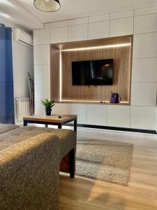 ein Wohnzimmer mit einem Fernseher an der Wand in der Unterkunft Iulius Mall Loft in Iaşi
