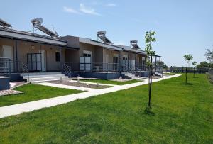 a building with a green lawn in front of it at GERANI apartments in Órmos