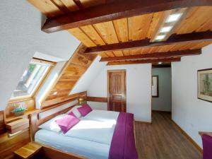 1 dormitorio con 1 cama con techo de madera en Plitvice Ethno House, en Jezerce