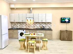 a kitchen with a table with fruits on it at Комфортные апартаменты Smart in Khmelëva