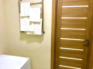 a bathroom with a toilet and a mirror and towels at Комфортные апартаменты Smart in Khmelëva