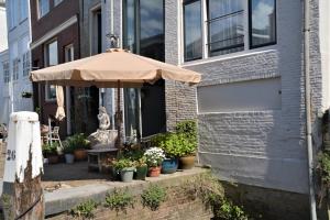 a patio with an umbrella in front of a building at B&B Appelsteiger in Dordrecht