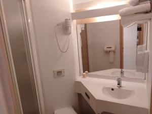 bagno con lavandino e specchio di Urban Style Arl HOTEL a Arles