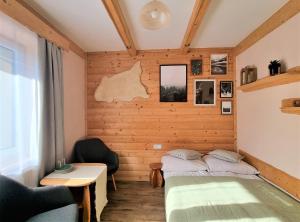 two beds in a room with wooden walls at Pokoje Pod Bocianem in Chochołów