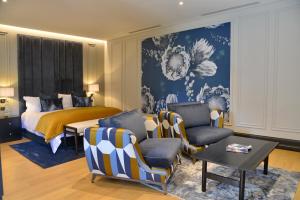 a bedroom with a bed and a couch and chairs at Apogee Boutique Hotel & Spa in Pretoria