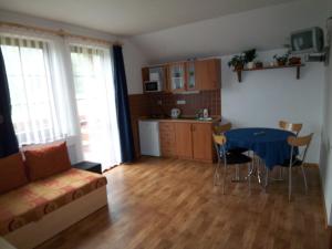 a living room with a table and a kitchen at Apartmány U Lanovky in Rokytnice nad Jizerou +2 photos