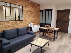 a living room with a couch and a table at L'Hébergerie in Époye