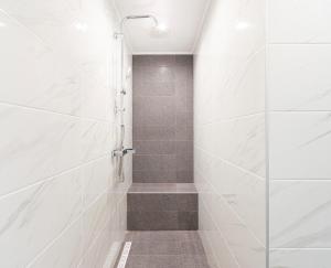 a bathroom with a shower with white tiles at Agnandi in Neos Marmaras