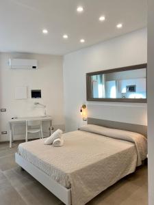 a white bedroom with a bed and a desk at Enjoy Olbia in Olbia