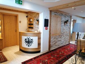 a room with a stone wall and a red rug at Tirol Appartement Haus Zillertal in Zell am Ziller
