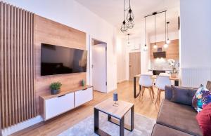 uma sala de estar com um sofá, uma televisão e uma mesa em LAGUNA Apartament Polanica Residence 2 em Polanica-Zdrój