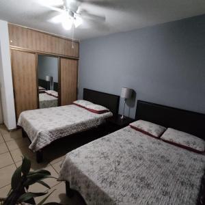 サン・カルロスにあるCasa Villa Serena 21のベッド2台と鏡が備わるホテルルームです。