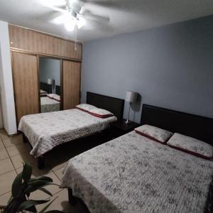 ein Hotelzimmer mit zwei Betten und einem Spiegel in der Unterkunft Casa Villa Serena 21 in San Carlos + 6 Fotos