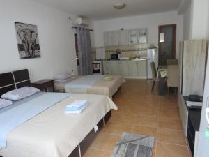 a room with two beds and a kitchen with a kitchen at Apartments Jovanović in Perast