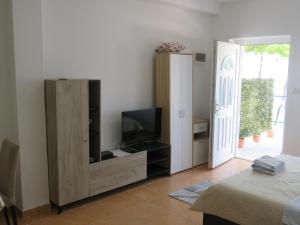 a living room with a tv and a entertainment center at Apartments Jovanović in Perast