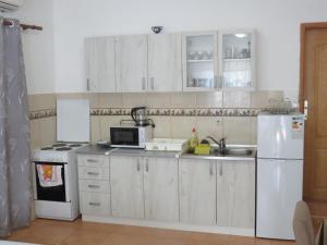 a kitchen with white cabinets and a white refrigerator at Apartments Jovanović in Perast
