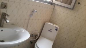 La salle de bains est pourvue de toilettes blanches et d'un lavabo. dans l'établissement Rediet Pension, à Addis-Abeba