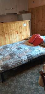 a bedroom with a large bed with wooden walls at LA CASETTA DELLA NONNA in SantʼAnna Pelago