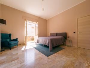 a bedroom with a bed and a chair and a window at FICU PALACE in Siracusa