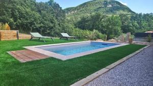 a swimming pool with a bench in the grass at Villa Larzac in Saint-Georges-de-Luzençon