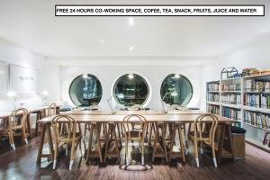 a large table in a library with chairs and mirrors at Blu Monkey Hub and Hotel Phuket Town- Free All Day Coworking space in Phuket Town