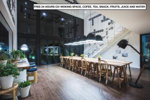 a restaurant with a long table and chairs at Blu Monkey Hub and Hotel Phuket Town- Free All Day Coworking space in Phuket Town