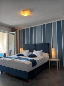 a bedroom with a large bed with blue and white stripes at Garfild Guest house in Novi Vinodolski