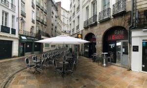 una calle vacía con mesas, sillas y una sombrilla en Hôtel Saint-Patrick, en Nantes