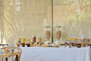 a white table with food on it in a room at Hôtel L'Escale Coté Port in LʼÎle-Rousse