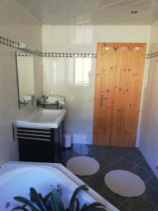 La salle de bains est pourvue d'une baignoire et d'une porte en bois. dans l'établissement Haus Barbara, à Forstau