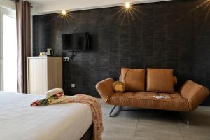 a hotel room with a bed and a couch at Hôtel L'Escale Coté Port in LʼÎle-Rousse